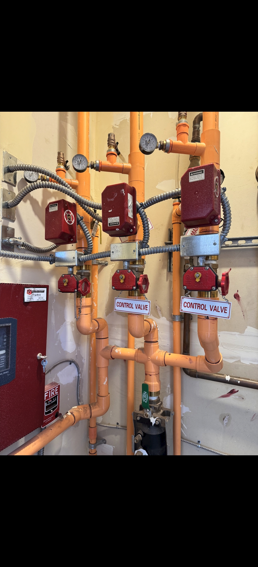 Installed orange sprinkler pipe drop and branch line inside framed construction area